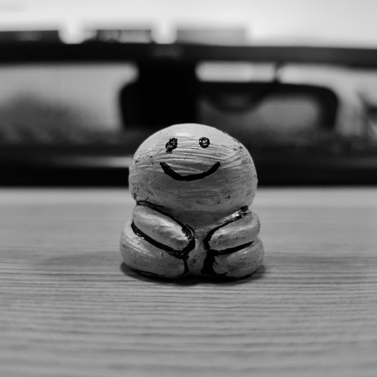 A white clay figure with a smiley face