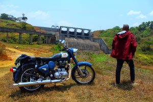 View larger photo: A motorcycle near a dam with person beside it.