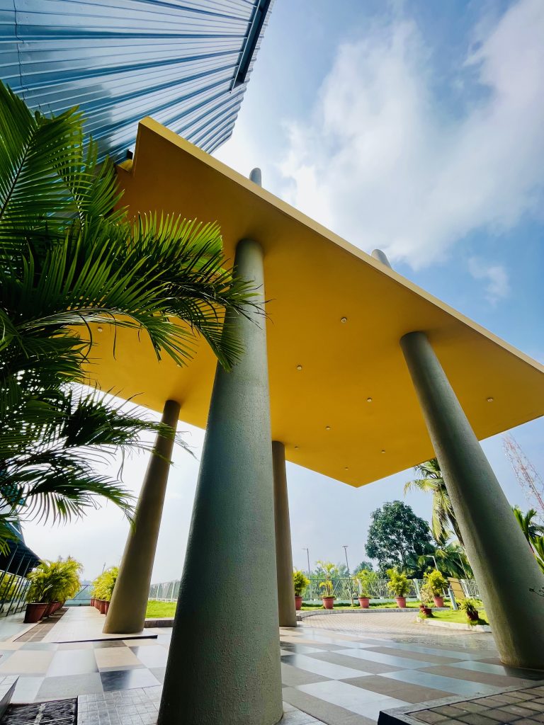 A yellow roof above the entrance of a large building, photographed from below at a steep angle.