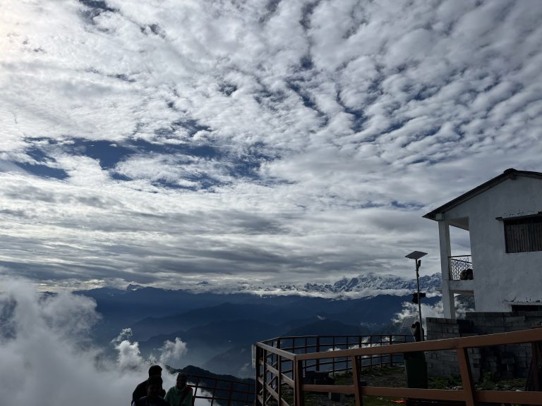 A stunning sky adorned with clouds above a magnificent mountain landscape.