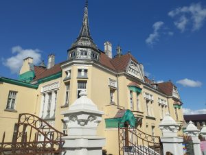 House of the Art Noveau style. Pale yellow walls, red tile roof, white windows and fence columns. House is called Chaim Frenkel Villa, taken in Siauliai, Lithuania.