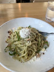 View larger photo: Pasta with white sauce, greens throughout, on a plate with a fork.