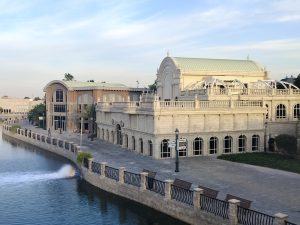  Riverland, Dubai. Large stone building witha. walkway by water.