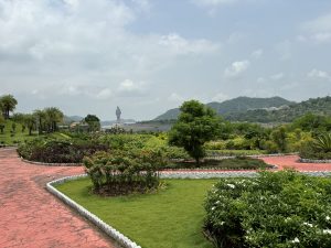 View larger photo: Park with a red brick walkway, lush greenery, and the statue of unity view in the background.