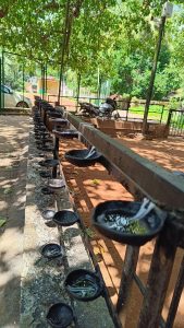 Black oil lamps placed in a parallel way in front of a temple 