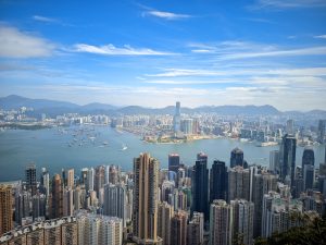 A panoramic view of a cityscape with numerous high-rise buildings and skyscrapers surrounding Hong Kong bay.