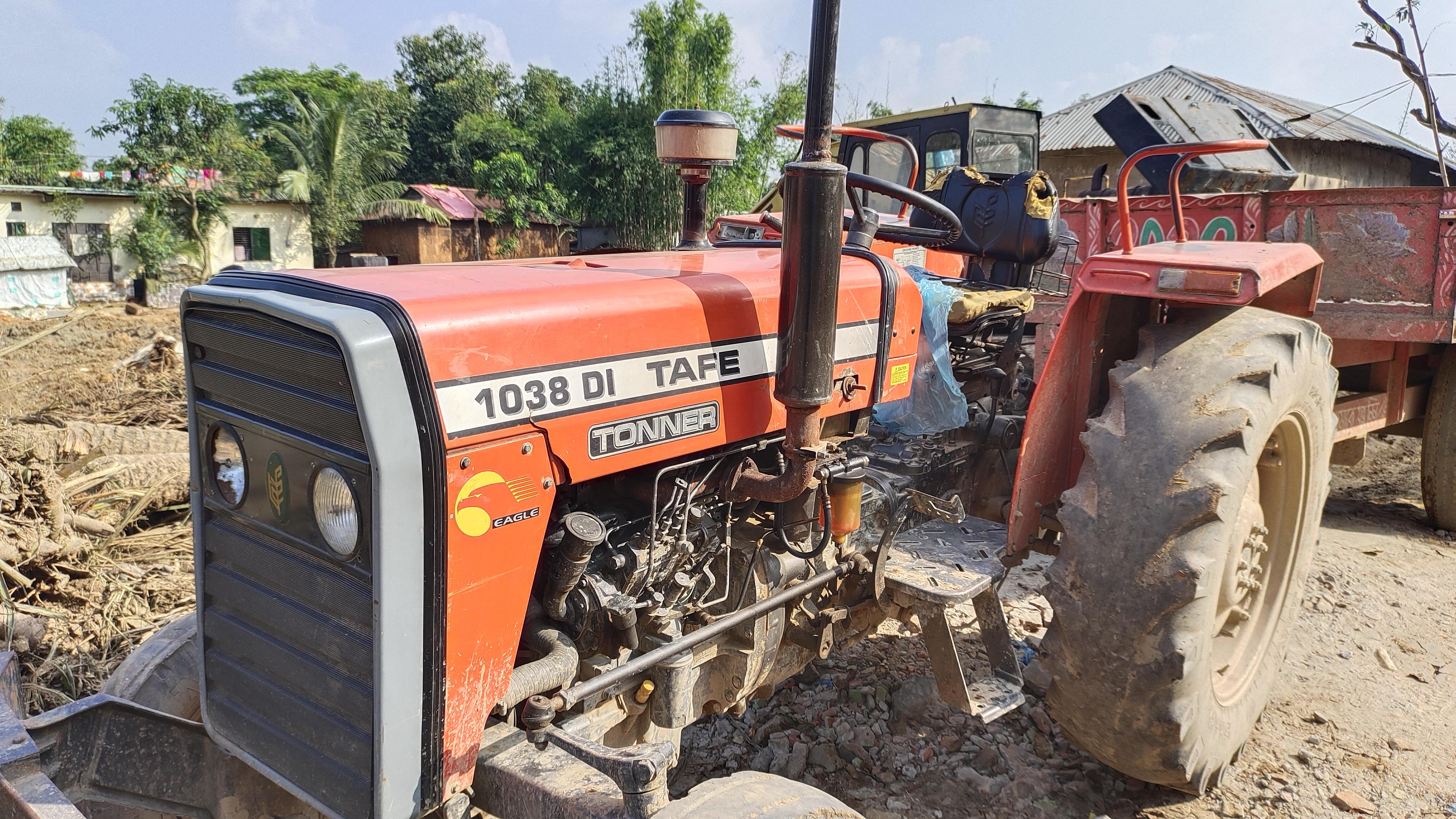 A parked tractor sits on a dirt surface, showcasing its rugged design and sturdy wheels.