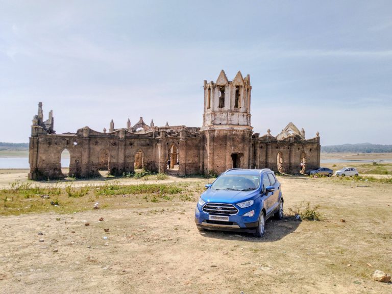 A blue color SUV parked in front of an old church, Shettihalli Church Hassan