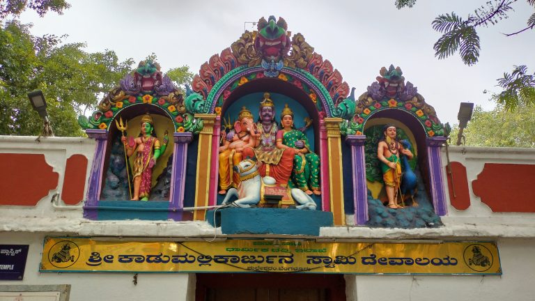 Graceful deity sculpture adorning the entrance, welcoming devotees with divine blessings.