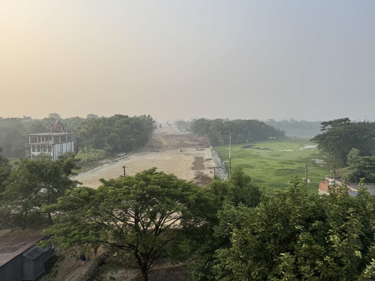 A tranquil winter morning captures a 150ft road stretching towards a distant river, enveloped in a frosty setting.