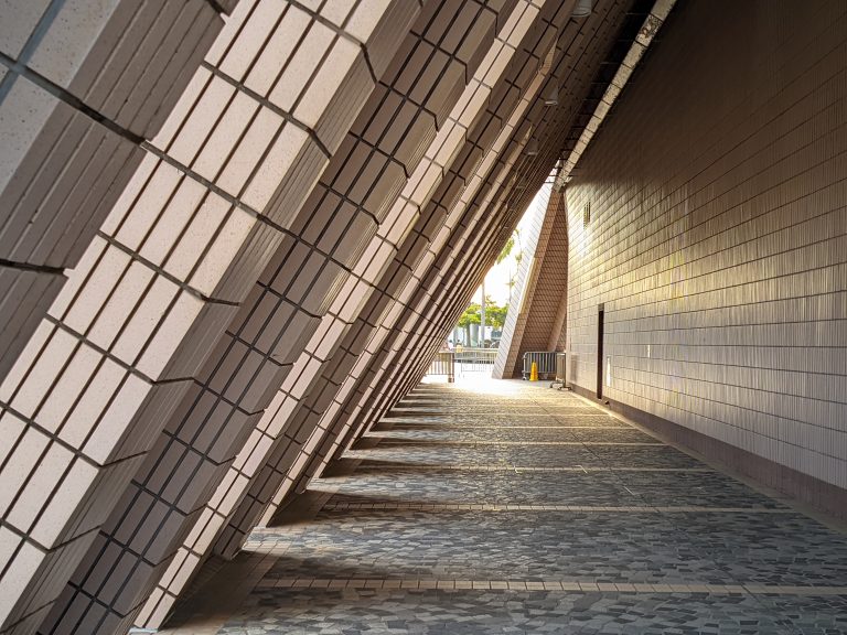 Under the post of a triangular building with a shade of sun during the golder hour