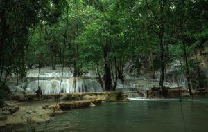 Majestic tiered limestone terraces of Kaparkan Falls in Tineg, Abra, cascading with crystal-clear waters surrounded by lush green forest, creating a breathtaking natural wonder in the heart of the Philippines.