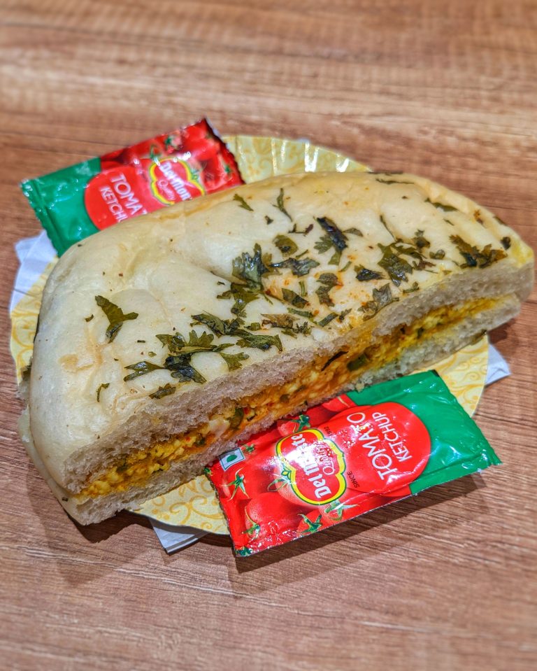 Paneer kulcha in a plate with red sauce