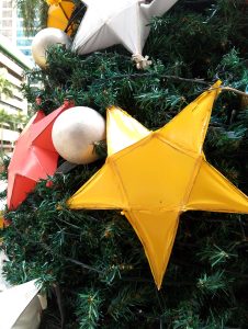 A decorative star ornament is placed on a Christmas tree, symbolizing joy and celebration during the festive season.