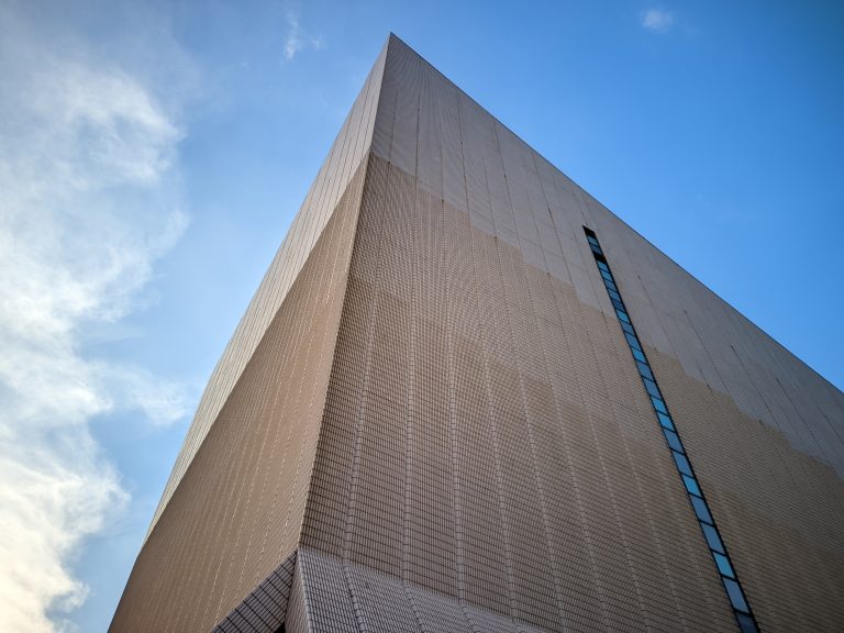 Facade of a building with a sky and cloud background