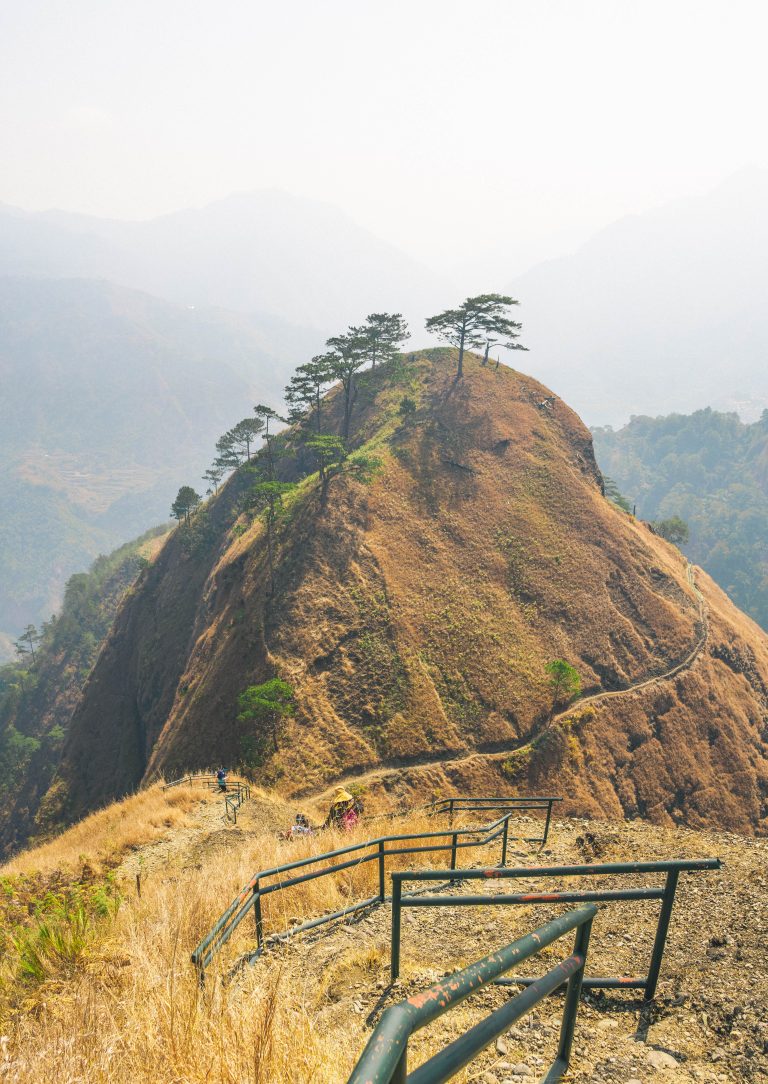 Wide shot from the top of the ‘Stairway to Heaven’ in Mt. Kabunian, revealing rugged peaks, misty valleys, and stone steps descending into the clouds below.