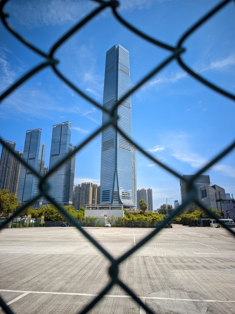 Building in a center behind a fence that looks like  a shadow