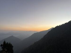 Early morning light breaks over the mountains, showcasing a beautiful sunrise that enhances the natural beauty of the landscape.