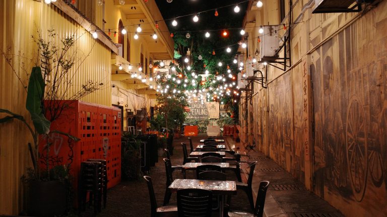 A row of neatly arranged tables and chairs in a well-lit indoor setting, ready for use.