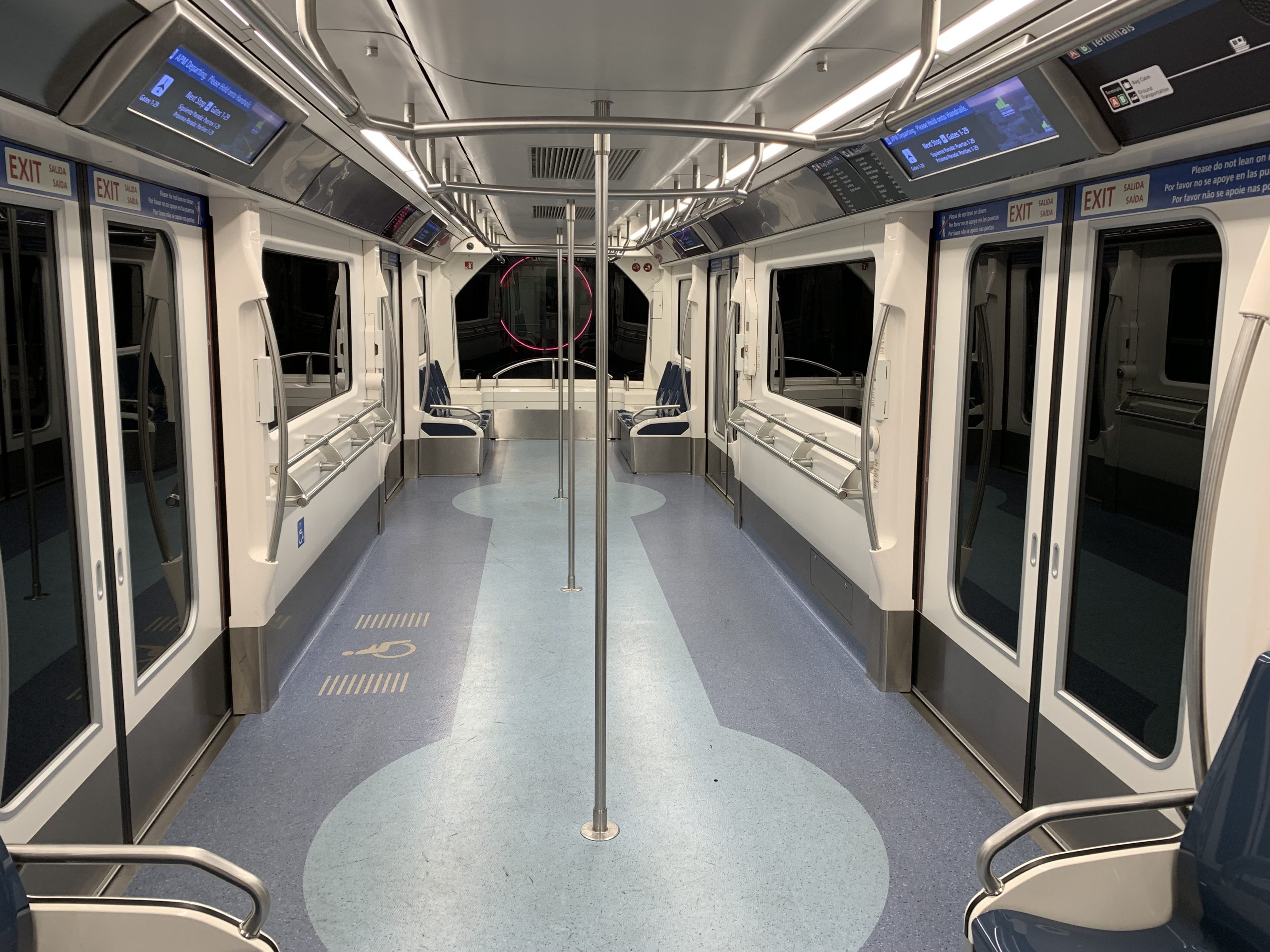 The inside of an empty airport shuttle train car in the Orlando International Airport.