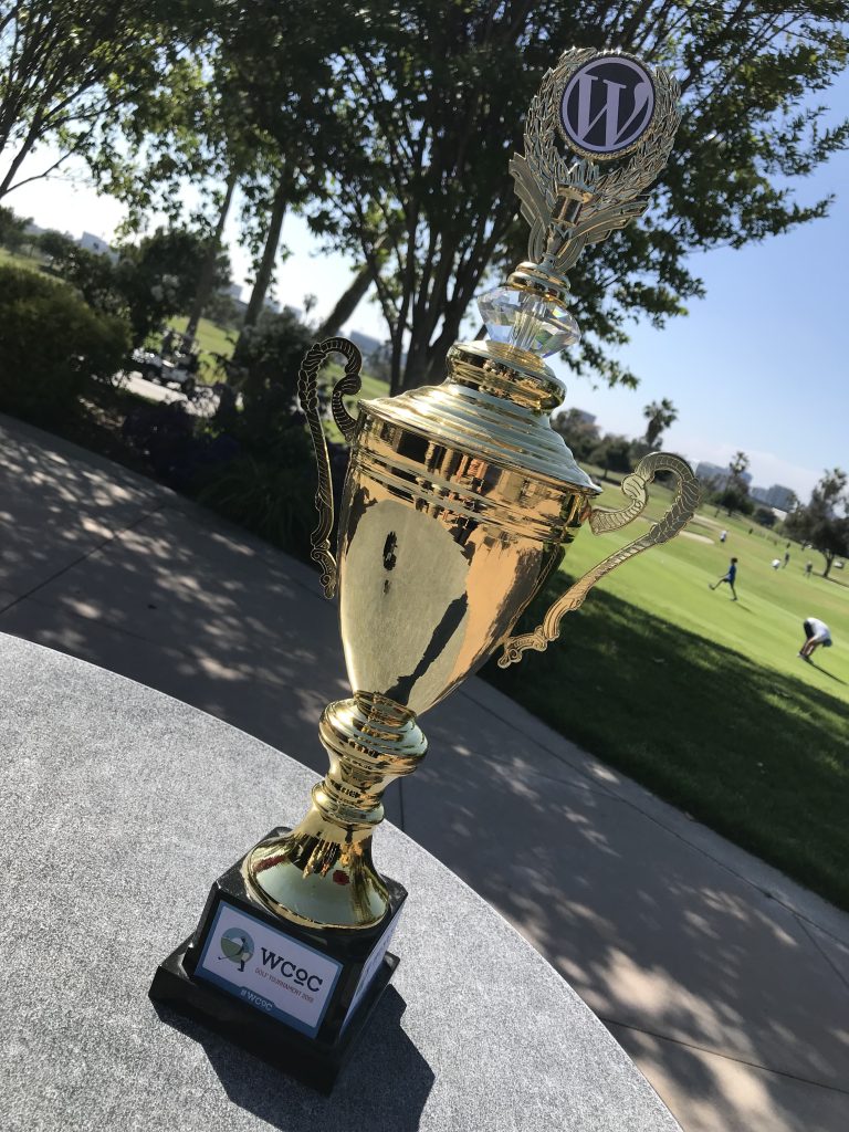 A gold trophy with the WordPress logo on the top for the 2019 WordCamp Orange County Golf Tournament.