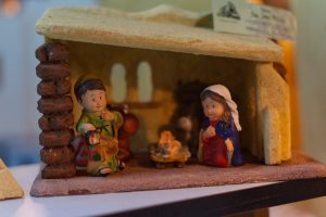 A small nativity scene featuring cute, cartoonish figurines of Mary, Joseph, and baby Jesus in a manger