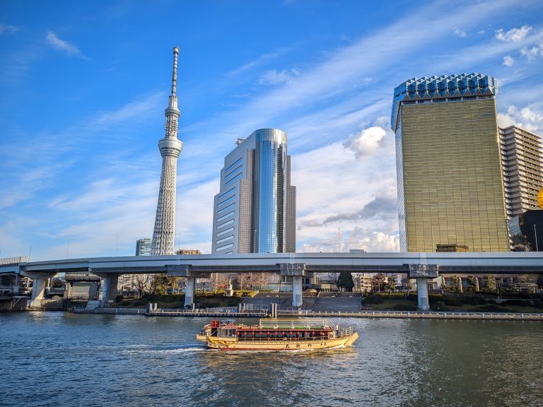 A ferry in a boat showing the Tokyo Skytree tower in the background