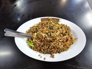 A white circular plate full of puffed rice. 
