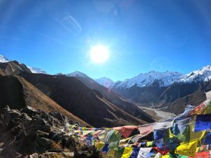 Sunrise summit views! Breathtaking panorama of snow-capped peaks and vibrant prayer flags. 