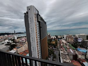 This long building in Pattaya, Thailand, stands out with its modern design and clean architectural lines. Nestled in a vibrant cityscape, it likely serves as a residential or mixed-use structure, offering convenient access to nearby attractions, shopping, and entertainment. Its sleek facade and urban appeal make it a notable feature of Pattaya