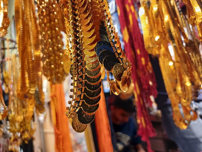 Traditional Indian gold jewelry. The items have intricate designs and some are shaped like coins or medallions.