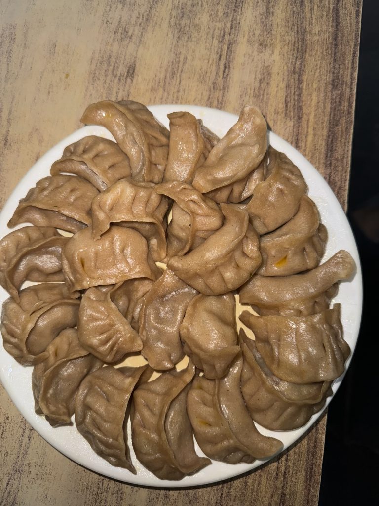 A plate of neatly arranged dumplings on a wooden table.