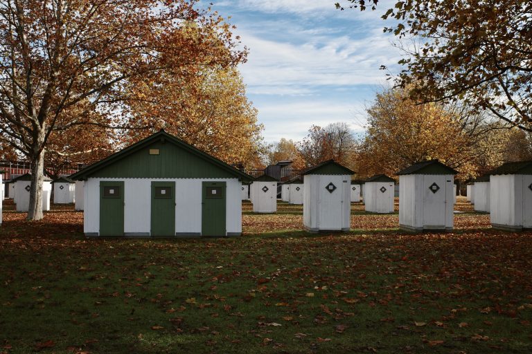 Changing boxes next to lake W?rthersee in Klagenfurt, Austria.  Sorrounded by trees and leaves on the ground.