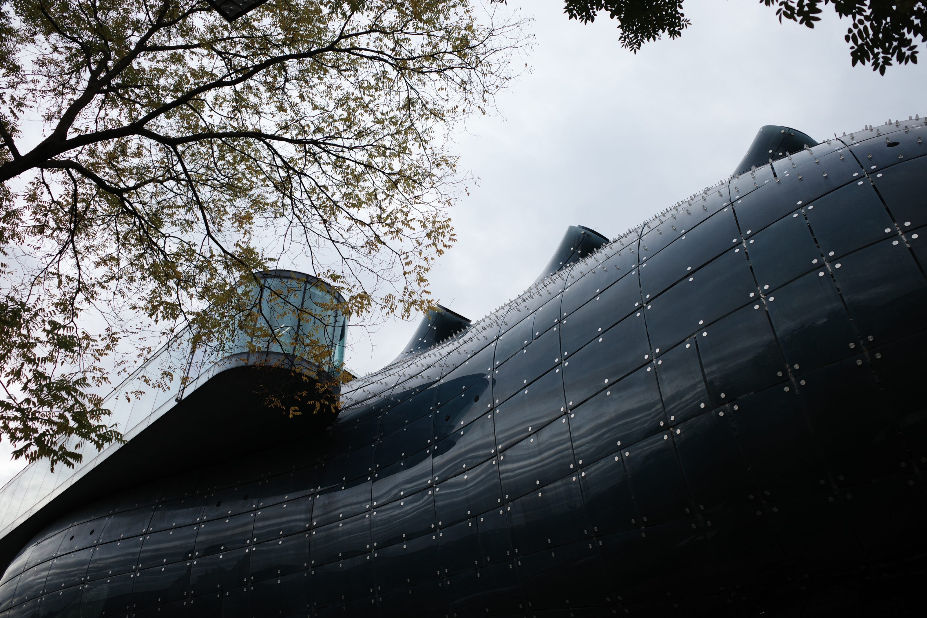 A contemporary art museum in Graz, Austria, featuring a striking blue glass facade and large black metal windows.