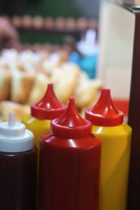 A close-up view of hot dogs topped with vibrant red ketchup, showcasing their appetizing appearance.