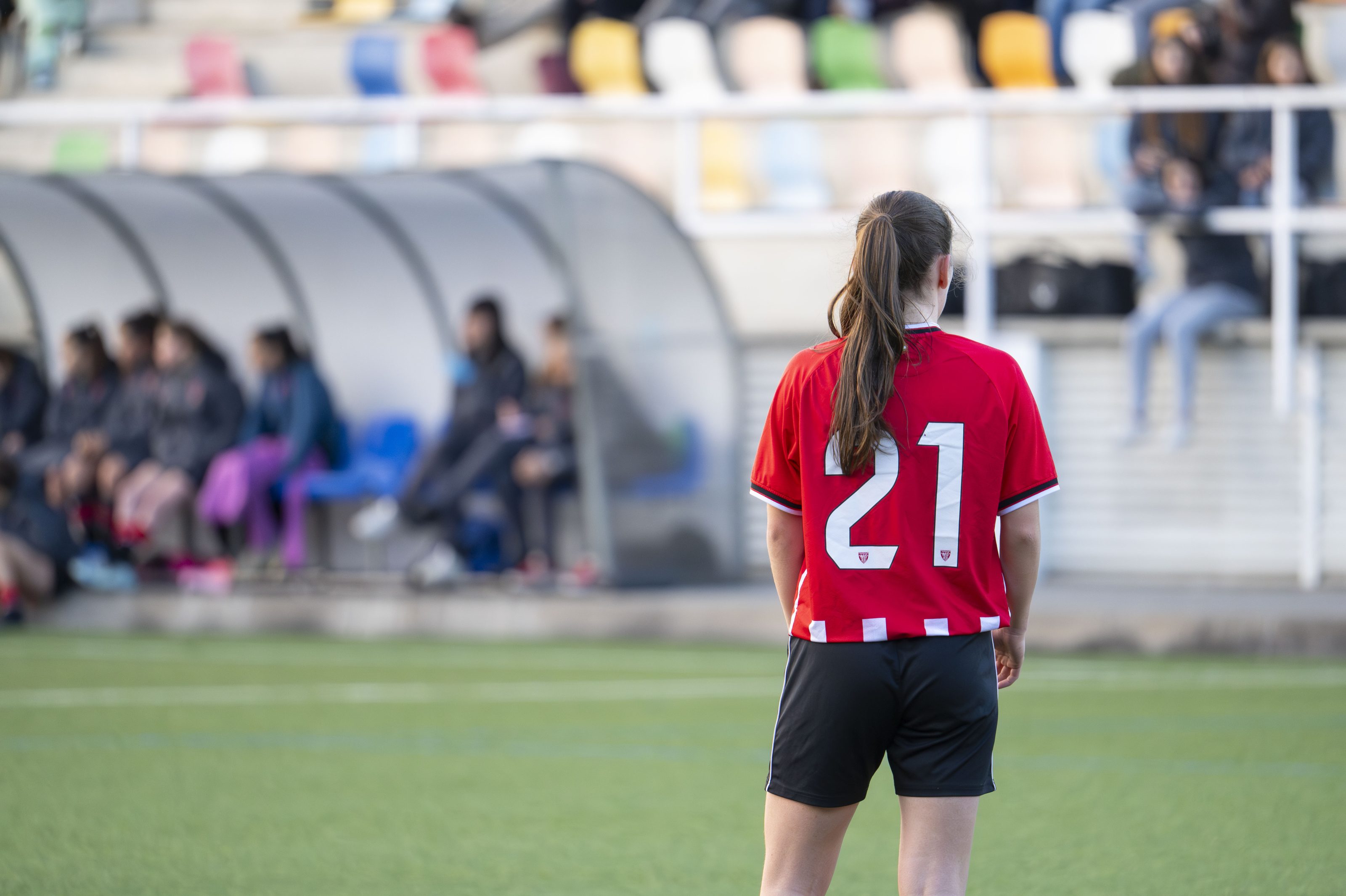 Female player on a soccer field with a jersey number 21