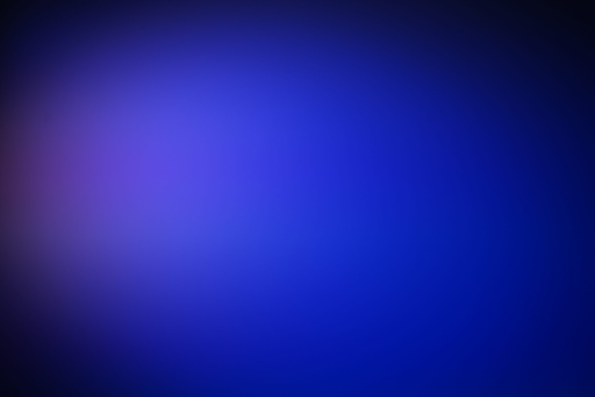 Stage lighting featuring a gradient background transitioning from dark blue to lighter blue and purple hues, creating a soft,