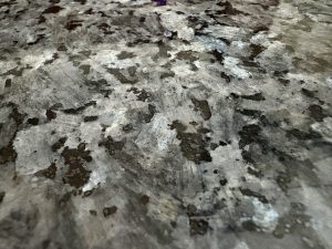 A dark granite countertop is filled with light gray, dark gray, and black flecks.