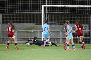 female soccer goalkeeper stopping a shot