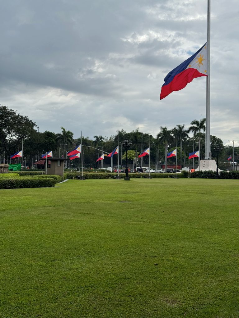 Philippine flags gracefully flutter in the park as people admire their vibrant colors, representing hope, unity, and true national pride.