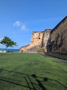 The historic Fort Jesus in Mombasa, Kenya, with its imposing stone walls standing tall. Captured from the edge of a football pitch in the foreground, the image also offers a glimpse of the Indian Ocean in the background
