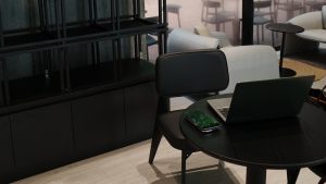 A sleek black table featuring a modern laptop positioned on its surface, showcasing a minimalist workspace.
