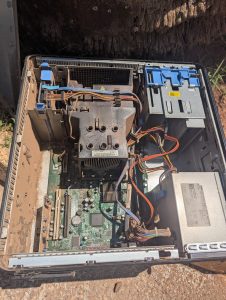 An open desktop computer case showing internal components, including a motherboard, power supply, cables, and a cooling fan. 