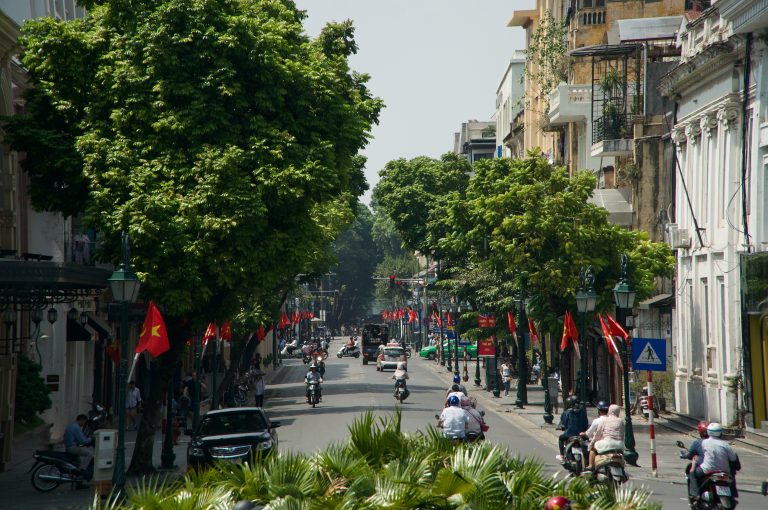 A street with traffic of people, cars and motorcycles in hanoi, Vietnam.