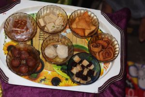 A tray containing various Indian sweets and snacks.