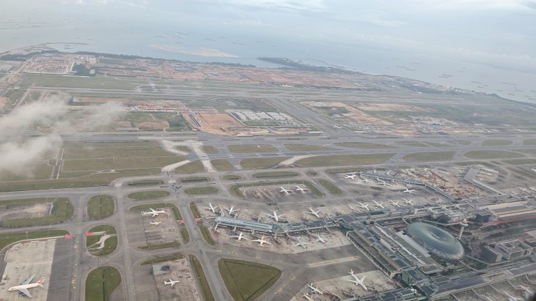 A bird’s-eye view angle of the Singapore airport, with aircraft looking like small birds from the view area.