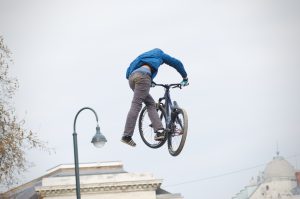 A rider performs a trick with a bike in a bmx competition.