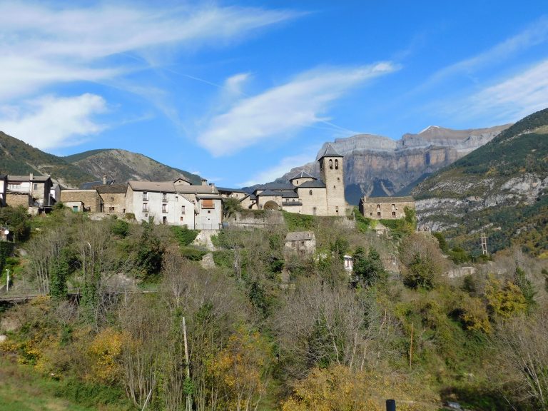 A picturesque mountain village in Broto, Aragón, Spain, featuring a charming church amidst scenic landscapes.