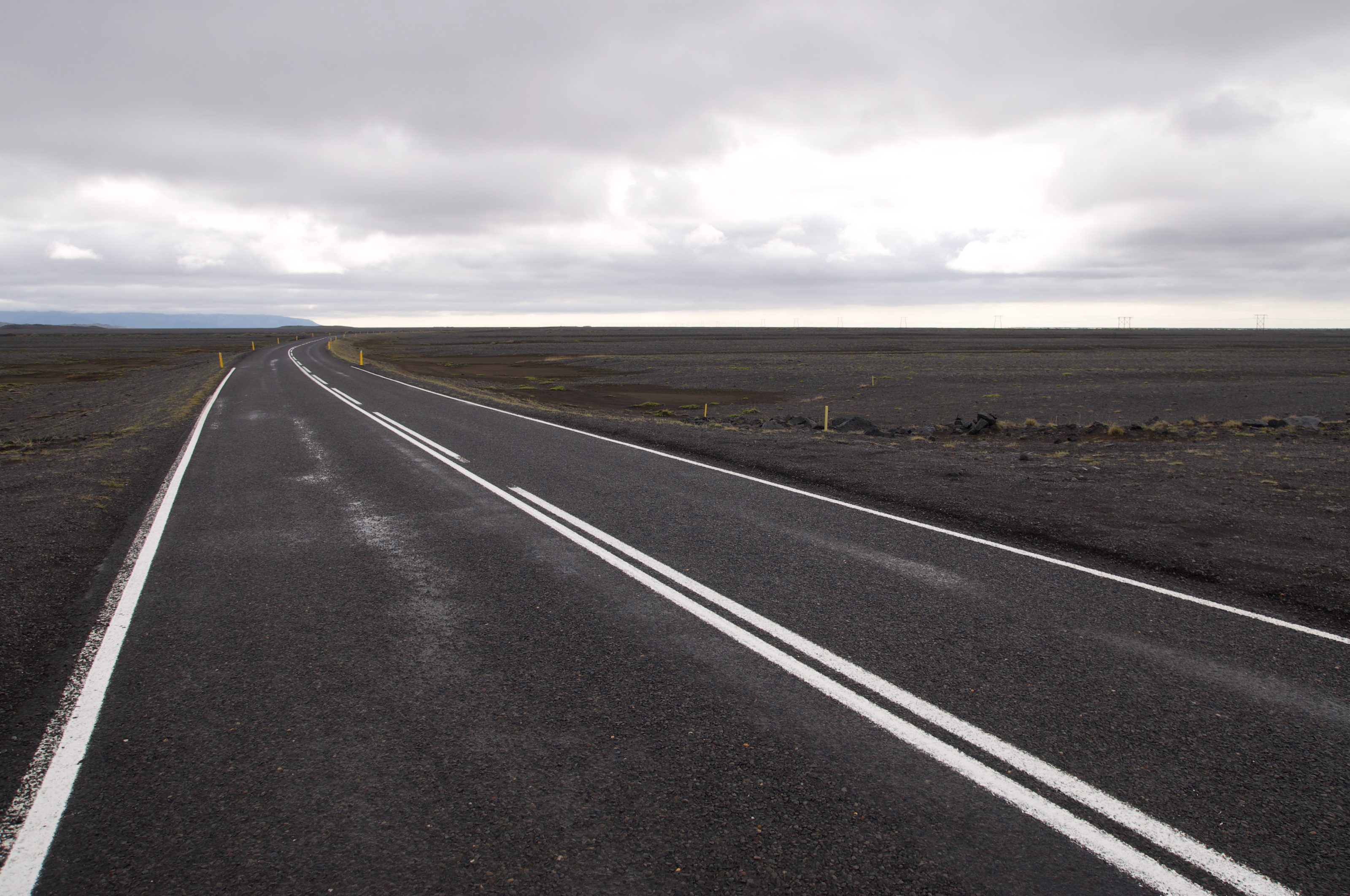 A dark road in an Icelandic volcanic landscape 