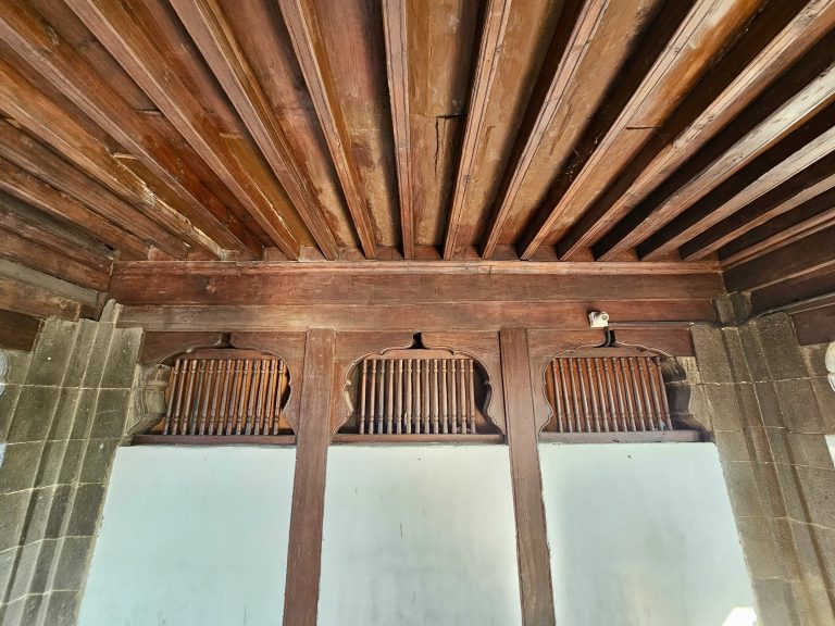 Interior detail of Shaniwar Wada, Pune (a 18th century monument) showcasing the wooden ceiling and arched window frames.